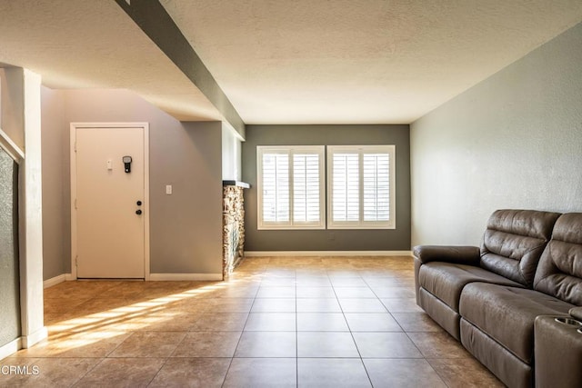 tiled living room featuring a textured ceiling