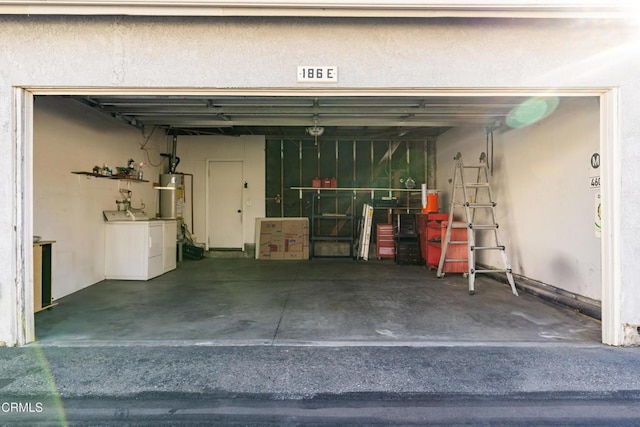 garage featuring washing machine and dryer and gas water heater