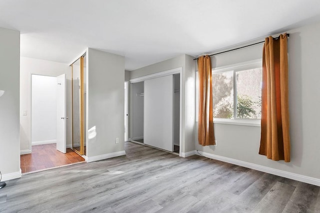 unfurnished bedroom with a closet and light hardwood / wood-style flooring