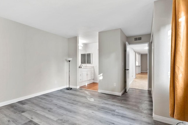 empty room with sink and light hardwood / wood-style flooring