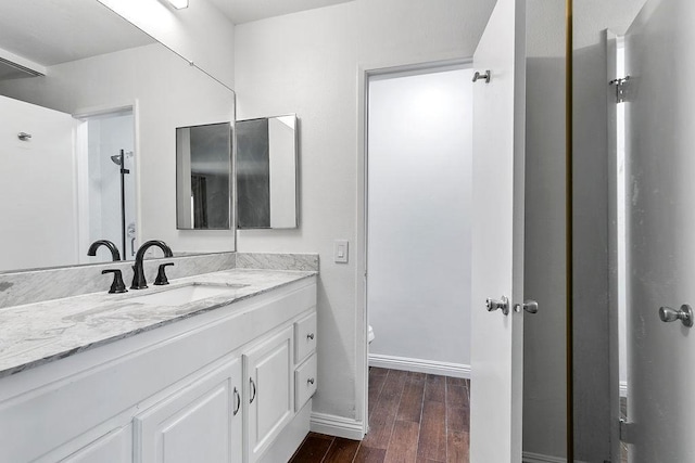 bathroom with toilet, vanity, and hardwood / wood-style flooring