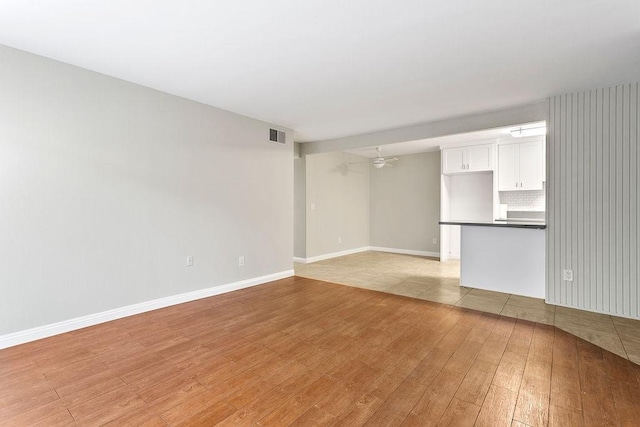 empty room with light wood-type flooring and ceiling fan