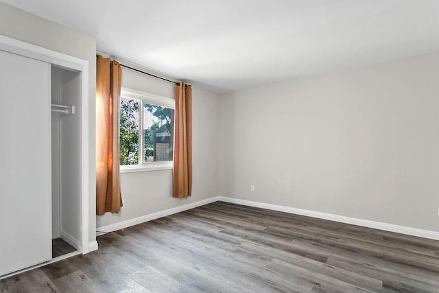 unfurnished bedroom featuring a closet and hardwood / wood-style floors