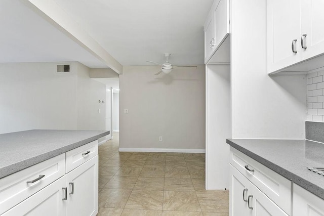 kitchen featuring light tile patterned floors, backsplash, white cabinetry, and ceiling fan