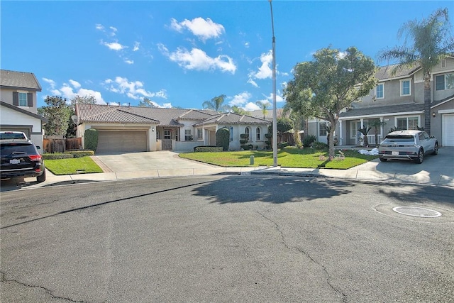 townhome / multi-family property featuring a garage, a residential view, a front yard, and driveway