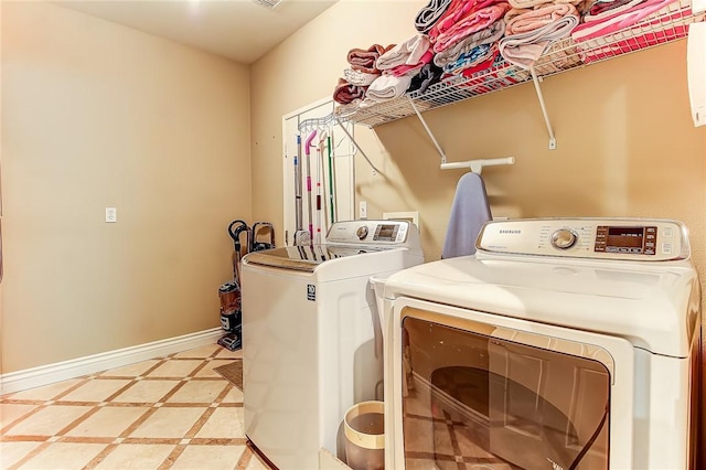 laundry room with light tile patterned floors and washer and clothes dryer