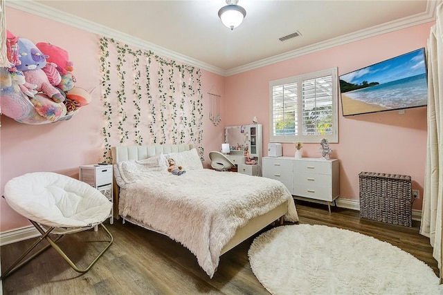 bedroom featuring crown molding, wood finished floors, visible vents, and baseboards