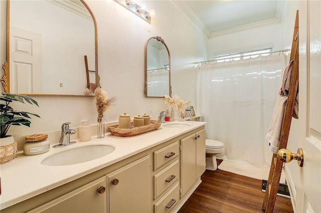 bathroom featuring ornamental molding, wood finished floors, toilet, and a sink