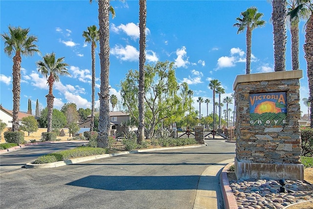 view of road with curbs and a gated entry