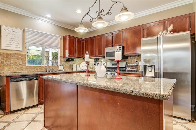 kitchen with a kitchen island, decorative light fixtures, sink, stainless steel appliances, and light stone countertops