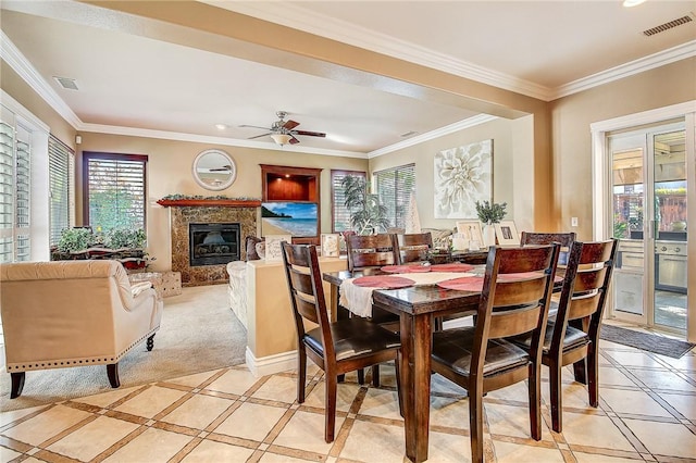 dining area featuring a premium fireplace, visible vents, and ornamental molding