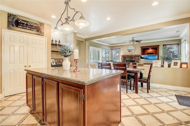 kitchen with a kitchen island, recessed lighting, baseboards, and ornamental molding