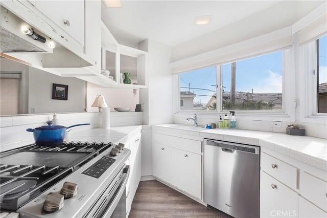 253 Fairview St, Laguna Beach, CA 92651 - kitchen with a sink, dark wood-style floors, stainless steel appliances, tile countertops, and white cabinets