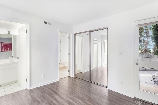 253 Fairview St, Laguna Beach, CA 92651 - unfurnished bedroom with a closet, wood finished floors, ensuite bath, baseboards, and visible vents