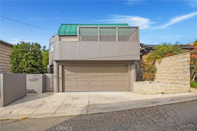 253 Fairview St, Laguna Beach, CA 92651 - view of front facade featuring metal roof, fence, an attached garage, concrete driveway, and a standing seam roof