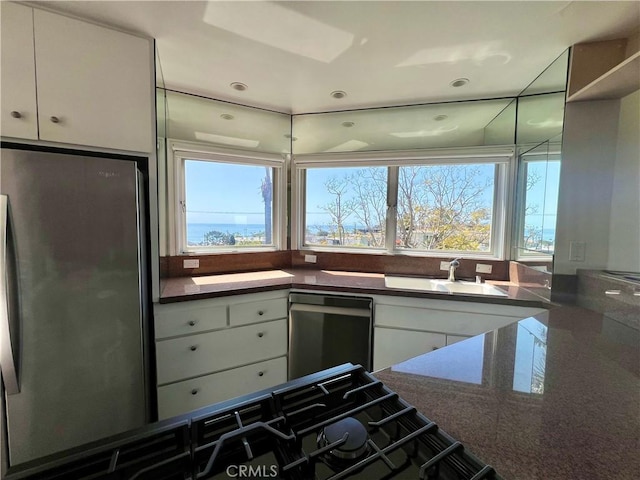 253 Fairview St, Laguna Beach, CA 92651 - kitchen featuring a sink, freestanding refrigerator, dishwasher, dark countertops, and white cabinets