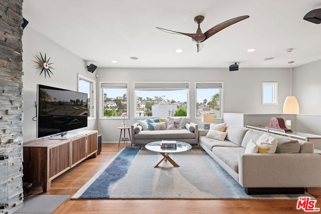 living room with light hardwood / wood-style flooring and ceiling fan