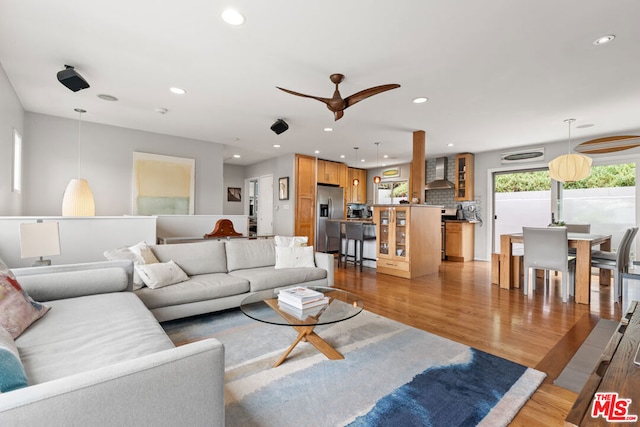 living room with ceiling fan and light hardwood / wood-style floors