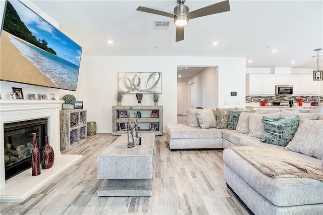 living room featuring ceiling fan and light wood-type flooring