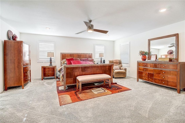 carpeted bedroom with ceiling fan and multiple windows