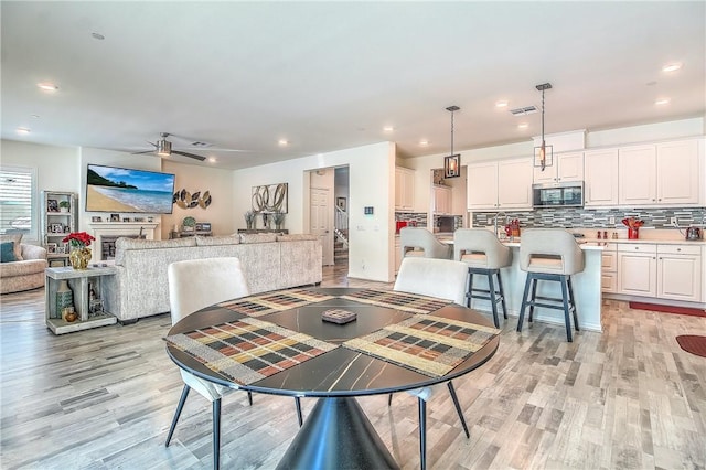 dining room featuring light hardwood / wood-style floors and ceiling fan