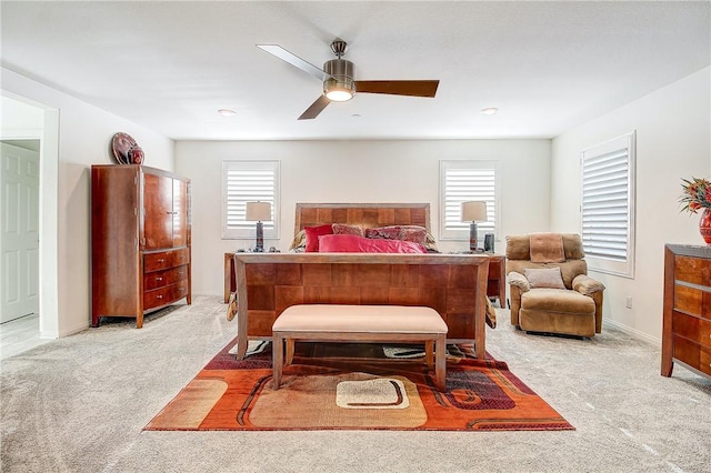 carpeted bedroom with multiple windows and ceiling fan