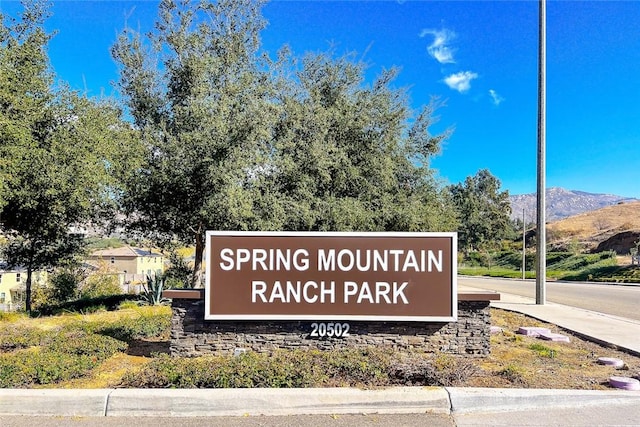 community / neighborhood sign with a mountain view