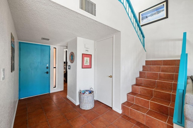 interior space featuring a textured ceiling and dark tile patterned floors