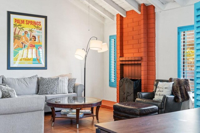 living room with vaulted ceiling with beams, light tile patterned floors, a fireplace, and wooden ceiling