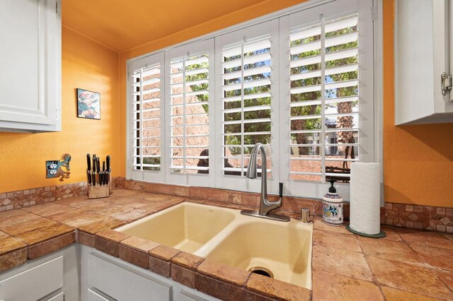 kitchen featuring white cabinets and sink