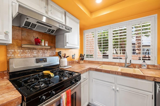 kitchen featuring tile countertops, white cabinets, a healthy amount of sunlight, and appliances with stainless steel finishes