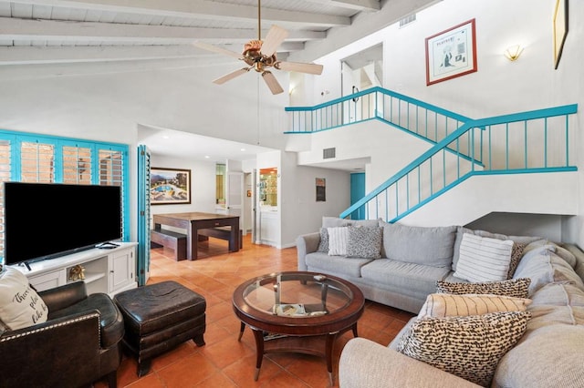 tiled living room featuring ceiling fan, beamed ceiling, and high vaulted ceiling