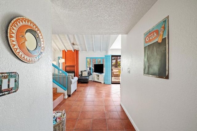 hall with tile patterned flooring, lofted ceiling with beams, and a textured ceiling