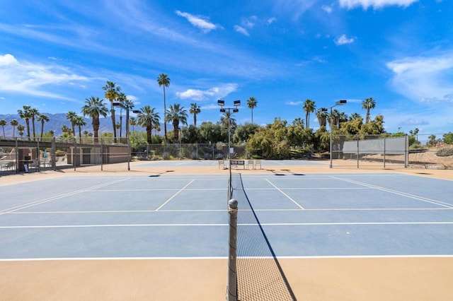 view of tennis court featuring basketball hoop