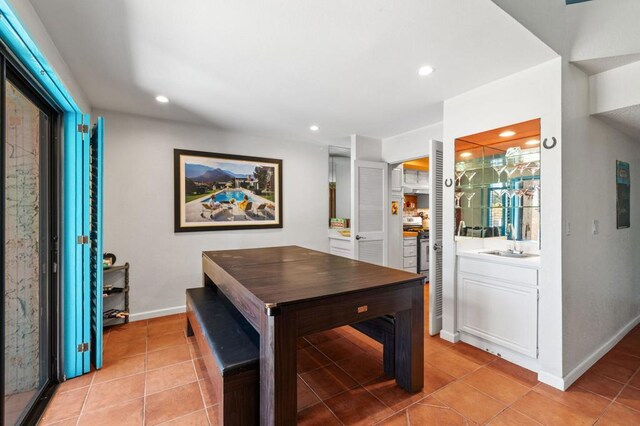 tiled dining room featuring sink