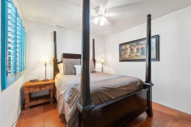 bedroom with ceiling fan, tile patterned flooring, and a textured ceiling