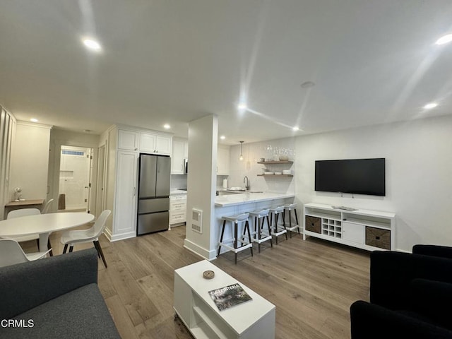 living room with sink and light hardwood / wood-style floors