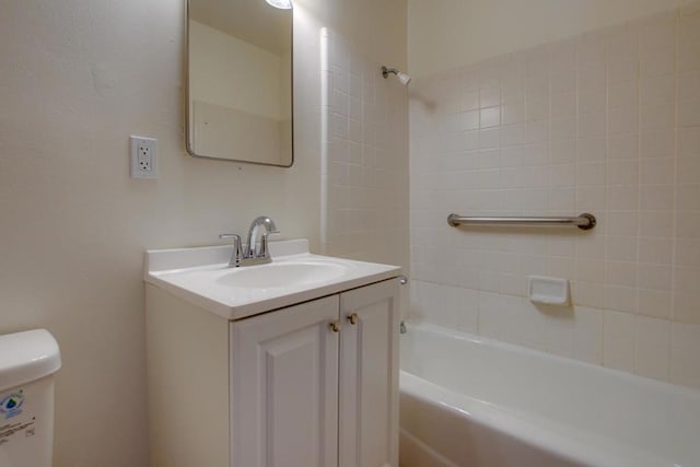 full bathroom with vanity, tiled shower / bath combo, and toilet