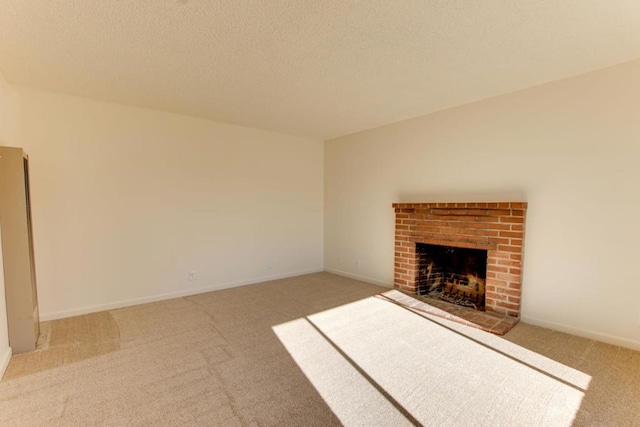 unfurnished living room with a brick fireplace, carpet floors, and a textured ceiling