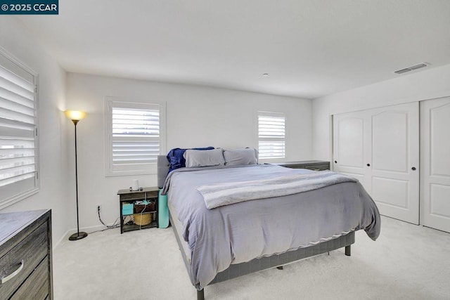 bedroom with light colored carpet and a closet