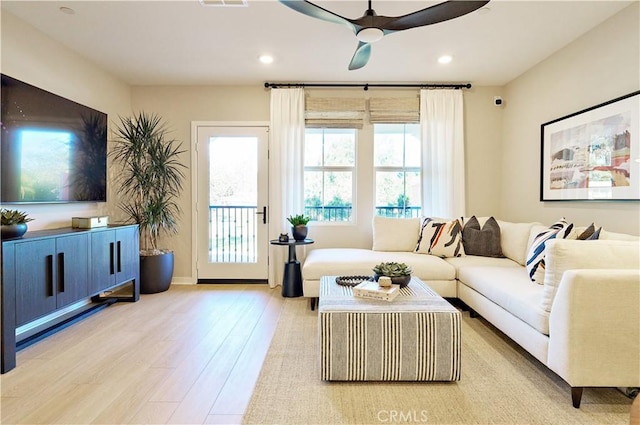 living room with light hardwood / wood-style floors and ceiling fan