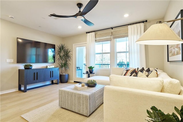 living room with wood-type flooring and ceiling fan