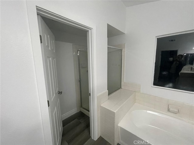 bathroom with hardwood / wood-style floors and shower with separate bathtub