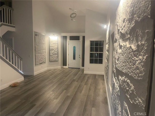 entryway featuring a towering ceiling and dark hardwood / wood-style flooring