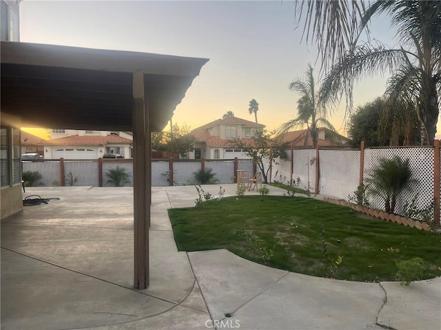 yard at dusk featuring a patio