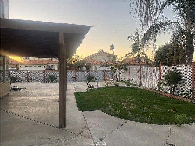 yard at dusk featuring a patio