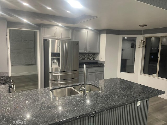 kitchen with gray cabinetry, sink, hanging light fixtures, dark wood-type flooring, and stainless steel fridge