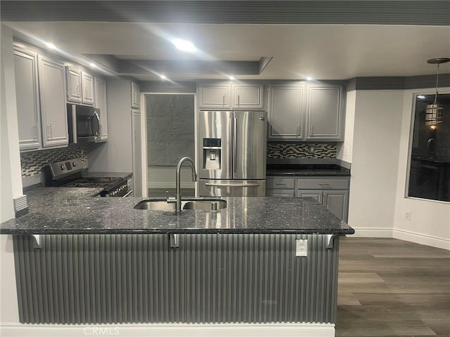 kitchen featuring gray cabinetry, sink, hanging light fixtures, kitchen peninsula, and appliances with stainless steel finishes