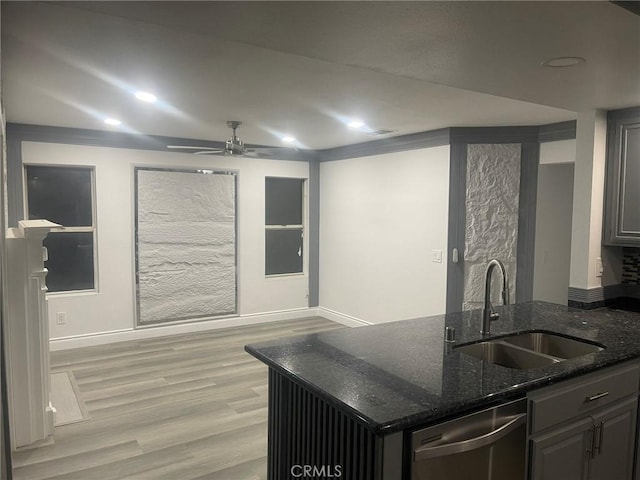 kitchen with ceiling fan, sink, light hardwood / wood-style flooring, stainless steel dishwasher, and dark stone counters