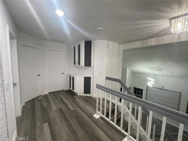 hallway with dark hardwood / wood-style floors and vaulted ceiling